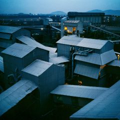 In a blue cityscape from Dayanita Singh's Blue Book series, interconnected roofs glow in the twilight.