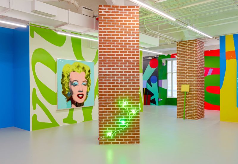 Installation view of The Street exhibition by Alex Da Corte, with neon patterned walls accenting the brightly painted pop art print of Marilyn Monroe's famous portrait.