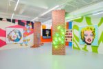 Installation view of The Street exhibition by Alex Da Corte, with neon patterned walls accenting the brightly painted pop art on the walls.