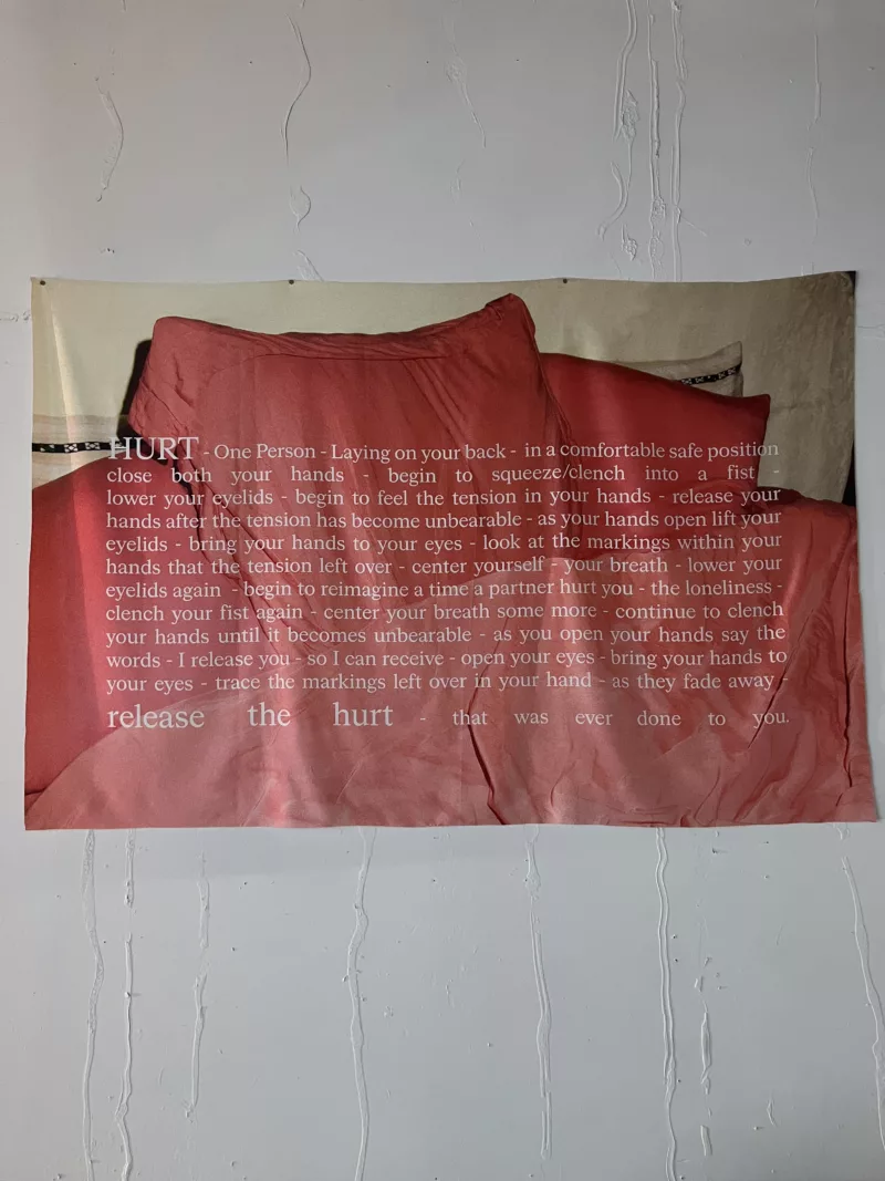 Entrance banner for the Asian Arts Initiative exhibition titled The Erotic Project. The banner displays a red bed spread with a poem on a white wall.