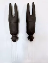 Two human figures in brown stoneware clay hang upside down. They are missing their arms and tears in the form of white twine fall out of their eyes.