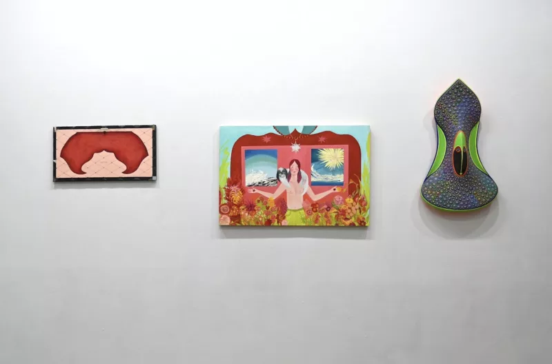 A gallery wall shows three paintings by three different artists that seem unified in their designs which use convex and concave curves to suggest the curves of the human form.