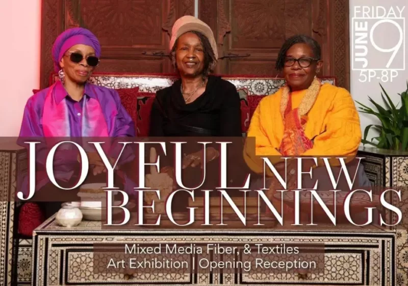 Three black women sit on a couch with an arabesque geometric pattern with a matching table. From left to right the women are Betty Leacraft, Akilah t’Zuberi, and Asake Denise Jones . Betty Leacraft is wearing a silk like purple shirt and head wrap, with dark black sunglasses. Akilah wears all black with rings on their finger and a septum. Their hair is in dreads in a hat. Asake is in a yellow shirt with an orange scarf, they wear gold hoop earrings and black framed glasses. Across the image is the title of the exhibition "Joyful New Beginnings" and "Mixed media fiber, & textiles Art Exhibition."