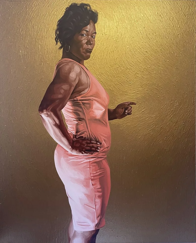 An iconic painting shows a muscular Black woman in a tight pink dress in sideview, looking at the viewer defiantly and pointing her left hand towards something out of the picture. Her right hand is on her hip, showcasing her muscle tone, and she is in front of a gold wall, with a golden light surrounding her head suggesting her spiritual nature; but another light, bright white and harsh, floods in from behind the woman and shines up on her as would “footlights” on a stage.