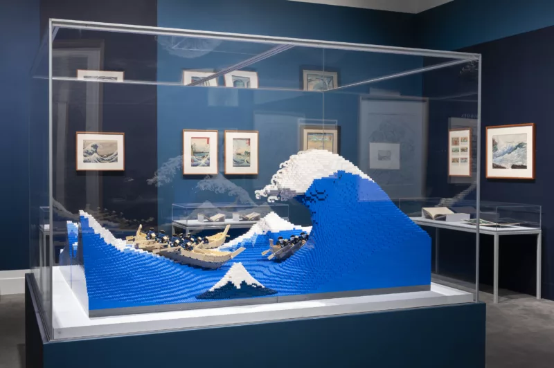 The great wave made into lego. With other woodblock prints in background as well as art inspired by Hokusai