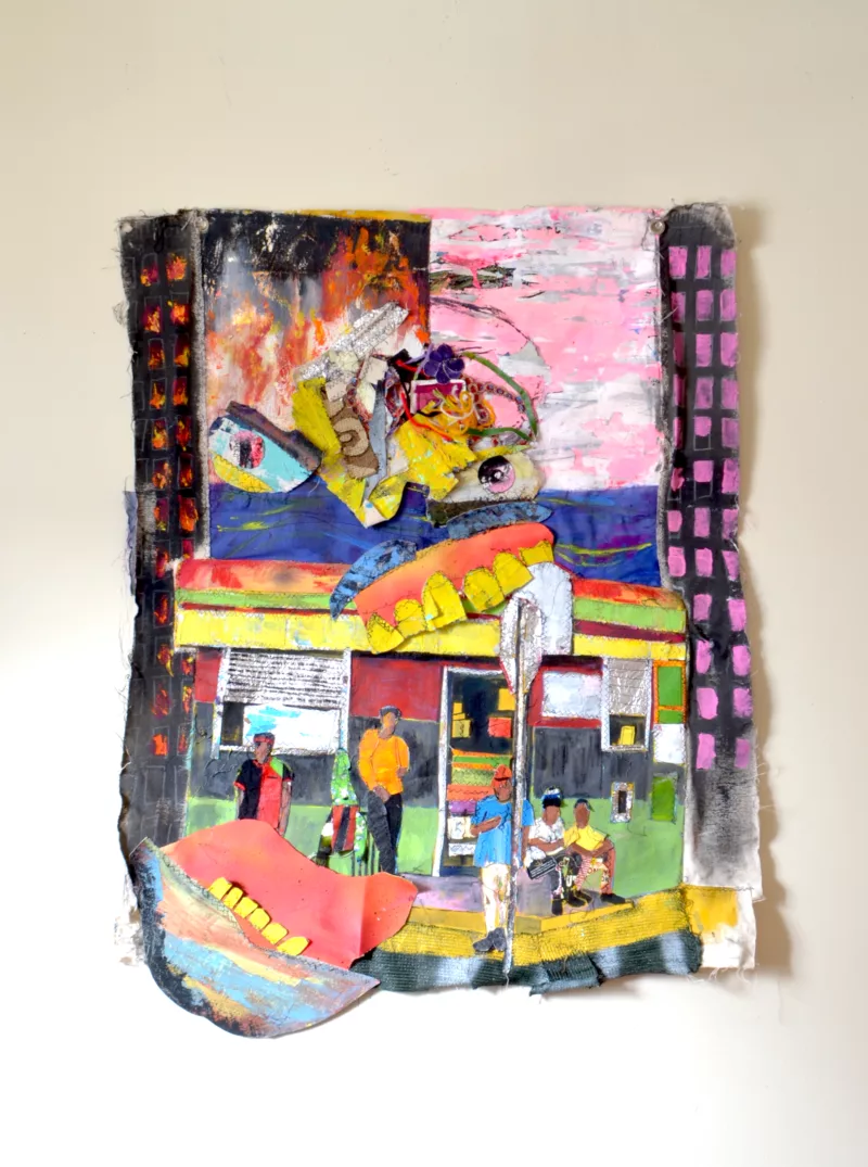 An assemblage by Eustace Mamba depicting a corner store and the people who sit out-front of it. The colors are bright and clash against eachother. A semi-abstract form of buildings appear alongside a face with wide open jaws and frenzied eyes. The left side of the assemblage depicts the building as if on fire while the right shows a calm pink, white, and black as if illuminated in the night.