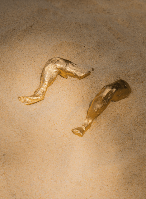 A photo of golden legs in sand.