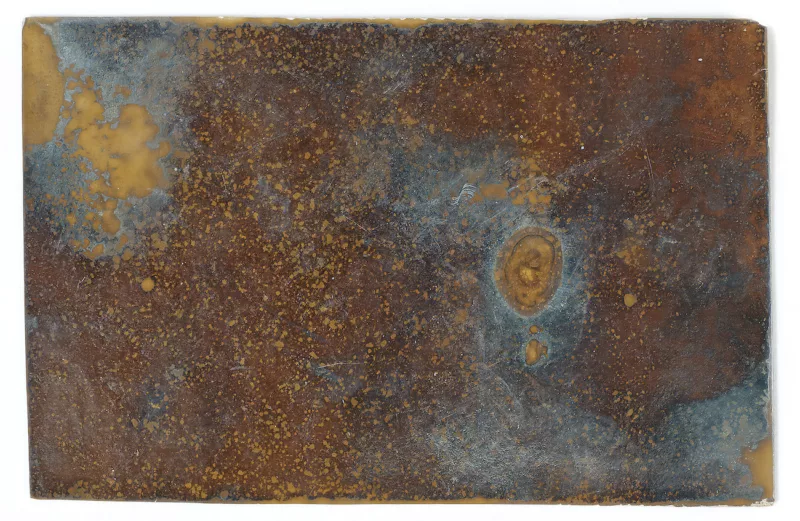 An experimental photograph from 1894 shows an abstract picture with nubbly orange bits on top of darker brown areas and in the background some blue showing through. In the top left, a large blotch of yellow with some further yellow outliers perhaps from that larger yellow blotch make a focal point. 