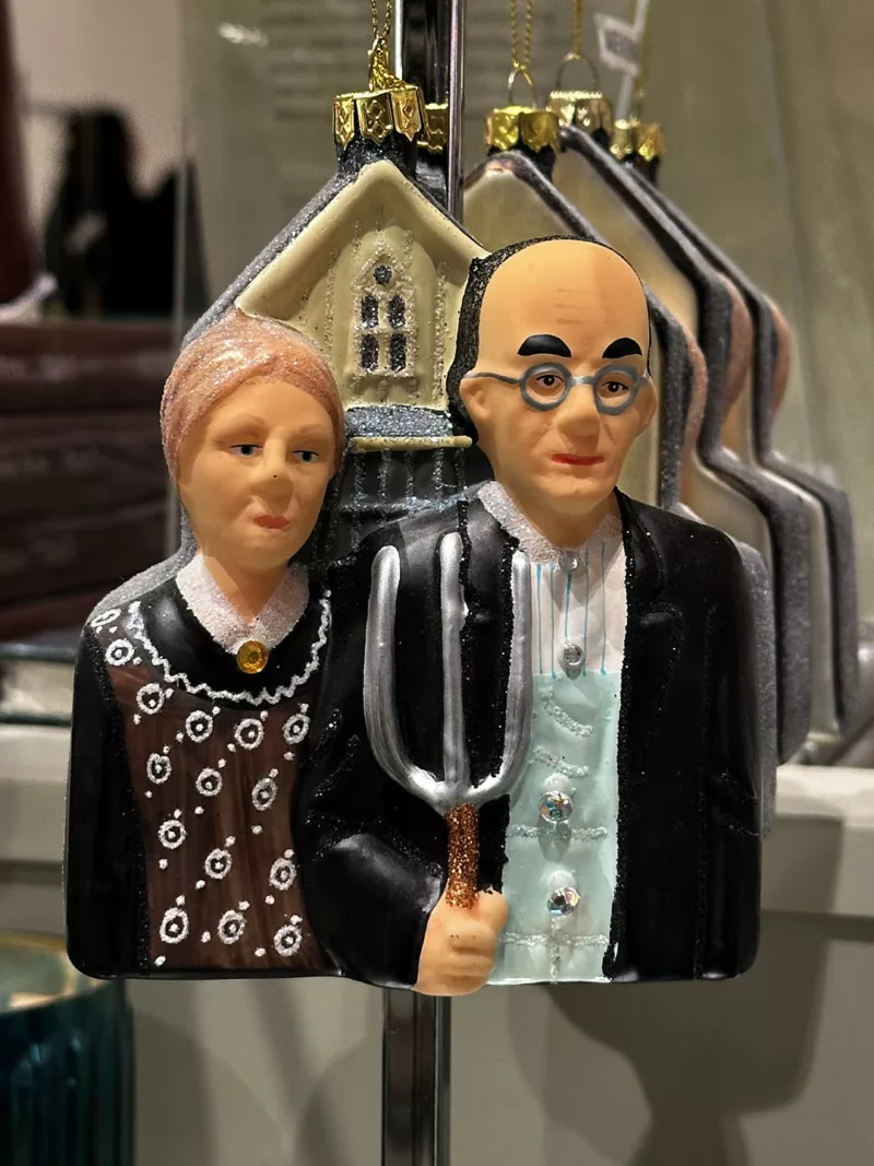 A 3-D Christmas ornament shows the farmer with pitchfork and his wife in front of a church, taken from Grant Wood’s iconic “American Gothic” painting.