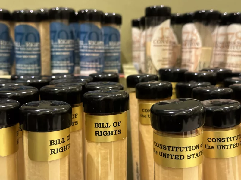 A vast number of canisters containing replicas of founding documents of the United States sits on shelves waiting to be selected for purchase.
