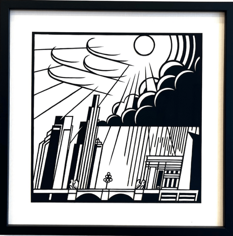 A square black and white paper cut-out image divided roughly in half, with a sun and stormy clouds above, and a cityscape with streaks of rain below.  