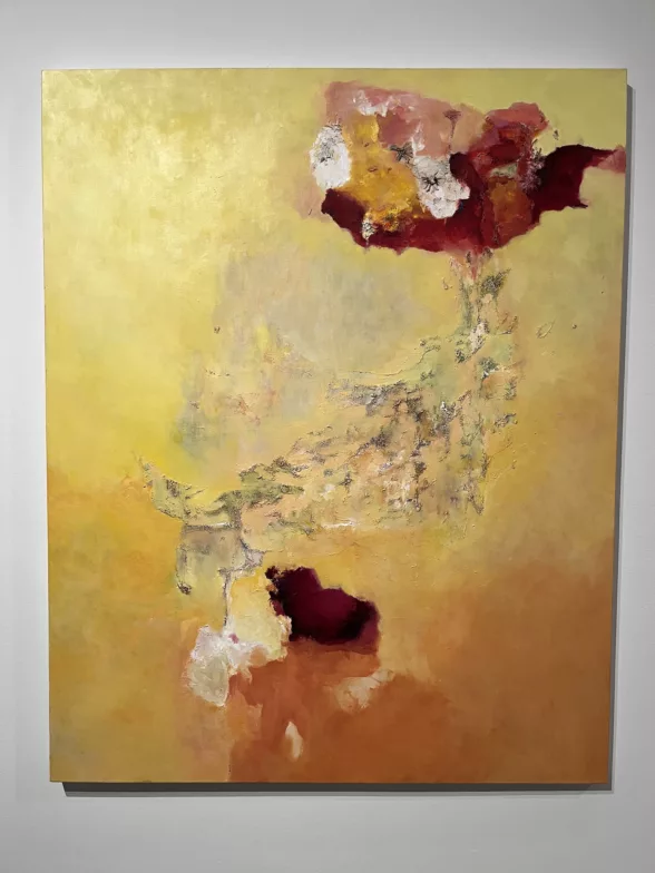 An abstract painting primarily in yellows, with touches of dark reds, ochres, white and green, evokes movement of breath or wind between two spheres. 