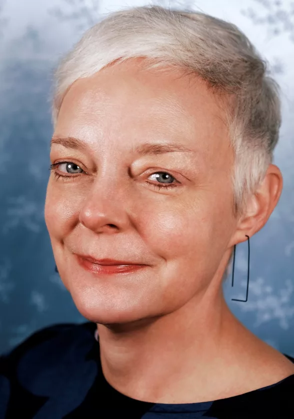 A head shot of a white woman, smiling, her white hair in a pixie cut and her black sweater circling her neck. She looks nice and approachable. She just became Assistant Director at a prominent Philadelphia Gallery.