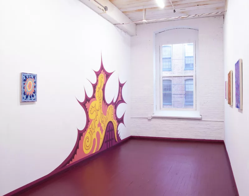 A small gallery with a large window has a purplish-red painted floor and on the left wall a mural painting in the same shade as the floor seems top raise up from the floor like a biological form that is multiplying.