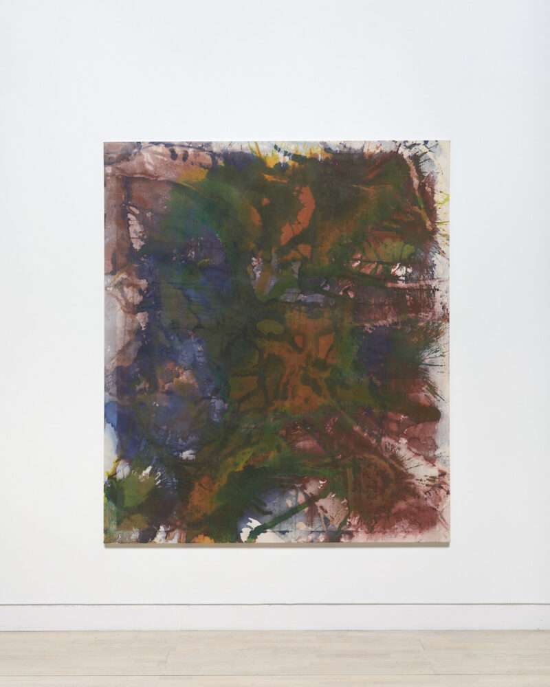A large abstract painting in Fall-like colors of orange, brown, dark green, purple and blue sits on a white gallery wall above a light wood floor. The paint has been poured, smooshed, brushed and dripped onto the canvas.