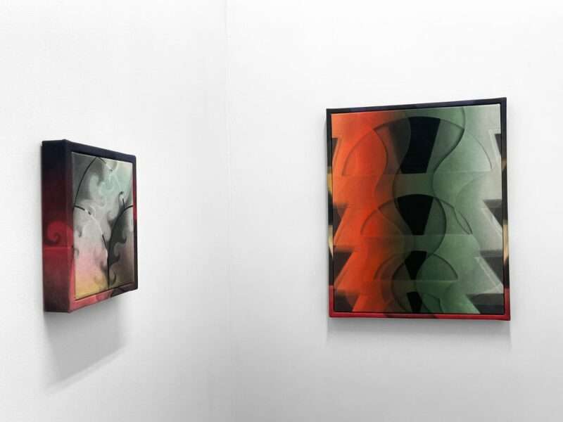Two works on adjoining walls, in colors from red to green to black and grey, portray repeat patterns that appear almost x-ray like of bones or machines