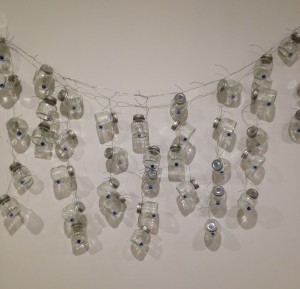“Until Tomorrow,”2003, glass bottles with metal caps, marbles, wire