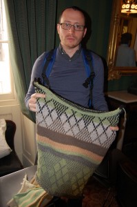 Adam Dalhgren of ADM Knitting shows off a sample of the type of fabric he will be making with visitors to create a giant sweater around the front of the Shivtei Yeshuron – Ezras Israel synagogue in South Philly. 