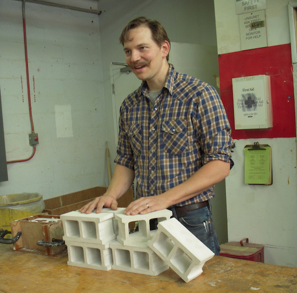 Lewis Colburn, showing us his hand-made half-scale cinder blocks.