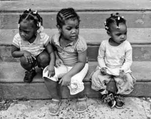 “Friends,” 2011. “This photograph is a part of a series that I shot in 2011 of children at a home-based daycare in Germantown. This scene, of three girls on the step, two looking in one direction with one looking in the opposite direction while one girl's hand rests on another girl's leg, is very poignant. It has a quiet sweetness to it that I love to capture in street scenes.” - Tieshka Smith