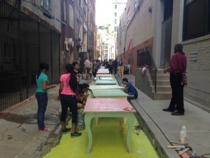 Particpants gathered to paint tables and chairs.