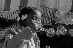 “Whimsy (Part 1),” 2013. “This photograph and its companion, “Whimsy (Part 2),” were made at a community-wide event that was held in Vernon Park in Germantown. I love how focused this little girl was on the fun she was having blowing bubbles and I wanted to capture that energy.” - Tieshka Smith